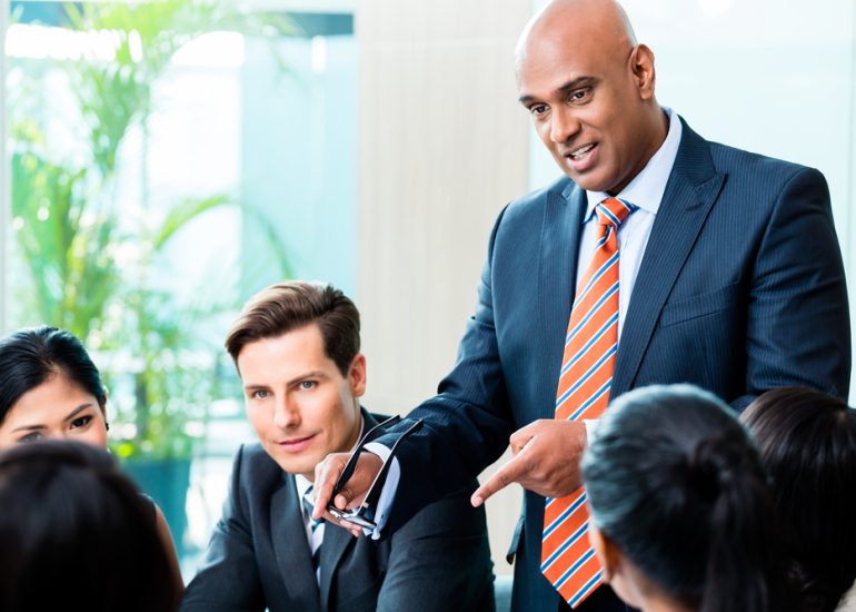 Indian Business Man Leading Team Meeting Indian Business man leading team meeting of diversity people in office